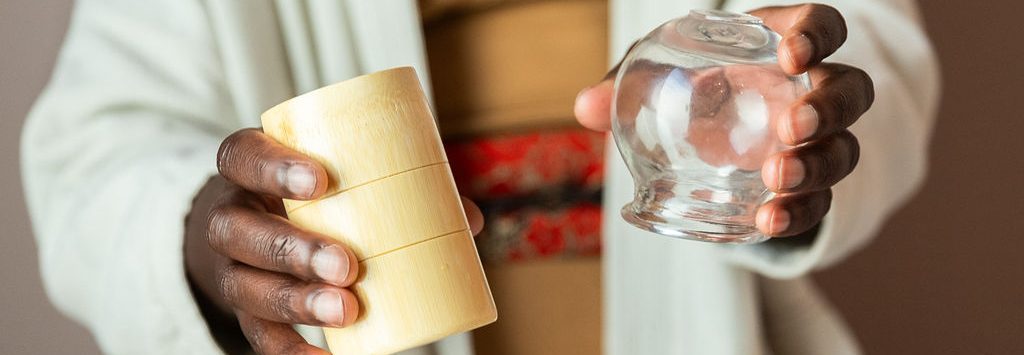 Mains tenant des ventouses en bambou et en verre